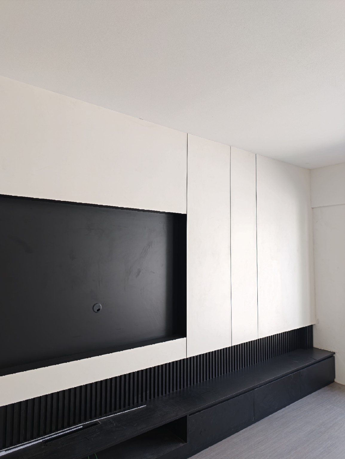 Real Chapter One Reno project: a completed TV feature wall with fluted wall panelling and a floating black media bench, Kuching